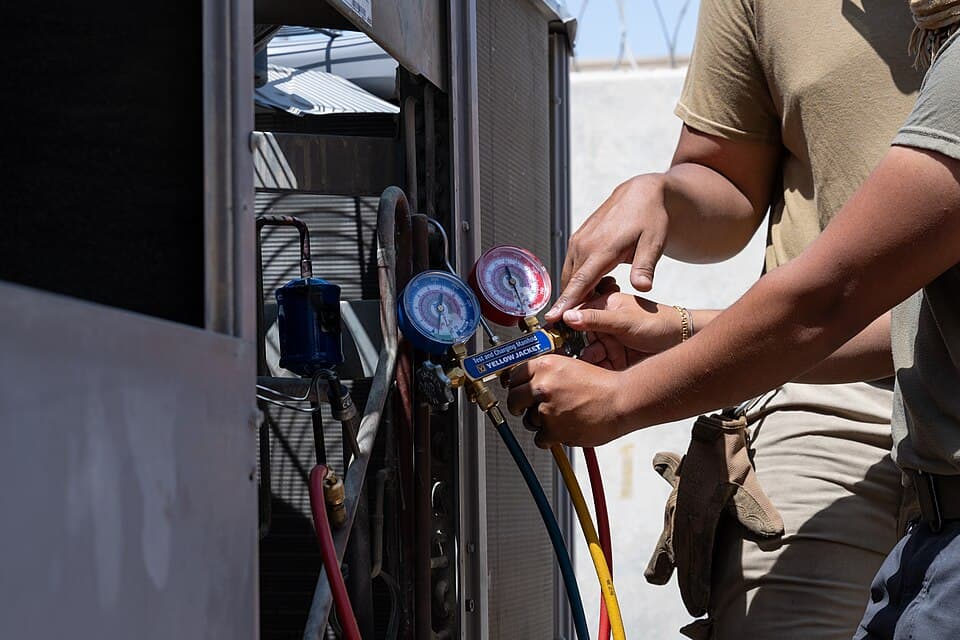 Technician inspecting an outdoor condensing unit